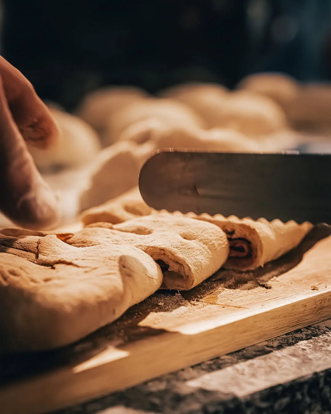 Uma faca abre os pães com chouriço acabados de sair do forno